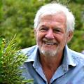 Smiling man David, 55, gardening with vibrant plants